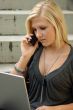 Young, blonde girl with laptop and mobile phone.