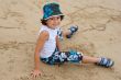 Pretty boy sitting on the sand from the beach