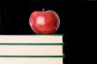 A red apple red on a green book