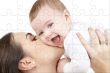 laughing baby playing with mother puzzle