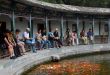 Chinese people looking at red carps in pond