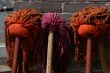 Three colored mops next to each other at the wall