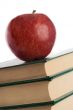 A red apple on top of books