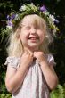 laughing little girl in flowers wreath