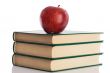 A red apple on top of three books