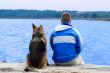 man and dog sitting on a sea berth
