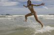 female teenager jumps on the beach