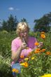 elderly woman is picking flowers