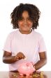 Girl putting a coin in a piggbank