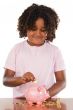 Adorable african girl putting a coin in a piggbank