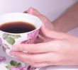 Female hands hold a coffee cup