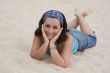 Adorable young woman lie down on the sand
