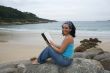 Young woman reading sitting on the beach