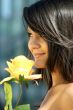 Young woman with a beautiful yellow rose