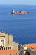 Cantainer cargo ship over Scilla cathedral
