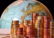 Stacks of Euro and Cent coins in front of a globe