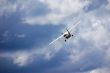 Small plane in blue cloudy sky