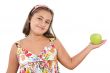 Adorable girl with flowered dress with a apple