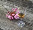 Glass of cognac and flowers on a wooden ancient table
