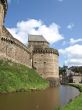 Tower of an ancient castle and protecting ditch with water
