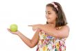 Adorable girl with flowered dress with a apple