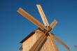 Rural wooden windmill against blue sky