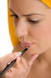 beautician putting lipstick on woman`s lips