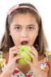 Adorable girl with flowered dress eating a apple