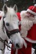  	Santa Claus holds white horse