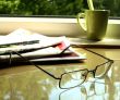 The eyeglasses, the newspaper  and the green cup