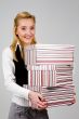 Smiling young woman with stack of boxes