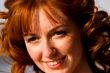 Bright portrait of red-haired young woman outdoors