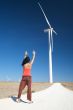 woman greeting wind energy mill