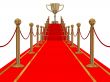 Gold cup of the winner on a red carpet path.