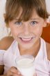 smiling girl with glass of milk looking