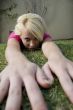 american woman lying with hands on grass