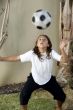 boy balancing football on his head