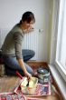 Young woman paints a wall in the kitchen