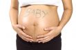 30 weeks pregnant teenager holding her belly with the word baby