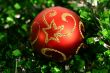 Red round sphere on a green tinsel