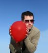 Red balloon in the hands of a man