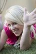 young woman lying on green grass