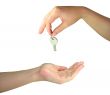 Two woman hands giving one another the key isolated over white