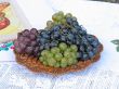 Grapes on a wooden plate with pattern and white canvas