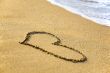 `Heart` drawing at sand, with sea wave
