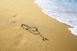 `Heart` drawing at sand, with sea wave