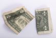 two crumpled one dollar banknotes