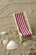 beach chair on the sand surrounded by shells