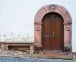 Entrance grey wooden door in a stone list