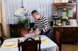 Grandfather is setting the table for breakfast